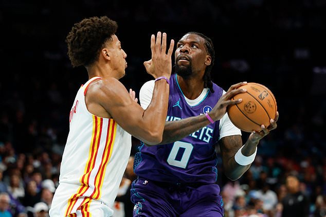 Charlotte Hornets center Naz Reid (0) looks to shoot against Atlanta Hawks forward Jalen Johnson, left, during the first half of an NBA basketball game in Charlotte, N.C., Friday, Oct. 23, 2026. (AP Photo/Nell Redmond)