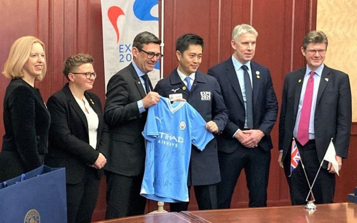 Andy Burnham presents a Manchester City football shirt to Hideyuki Yokoyama, Osaka's mayor in December 2023