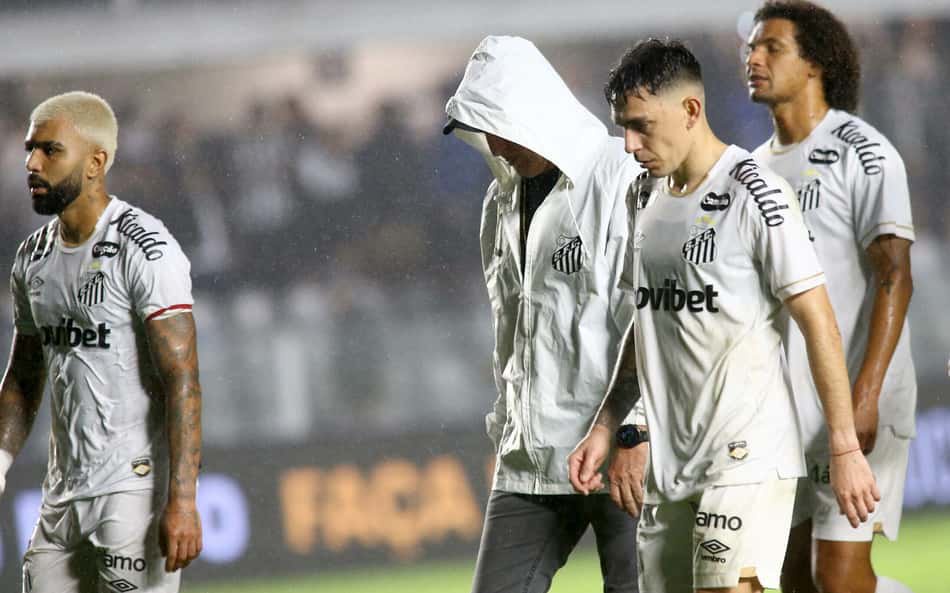 Escobar e Willian Arão saindo do gramado da Vila Belmiro sob forte chuva.
