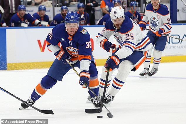 New York Islanders' Kyle MacLean (32) defends the puck from Edmonton Oilers' Leon Draisaitl (29) during the second period of an NHL hockey game Saturday, Oct. 31, 2026, in Elmont, N.Y. (AP Photo/Pamela Smith)