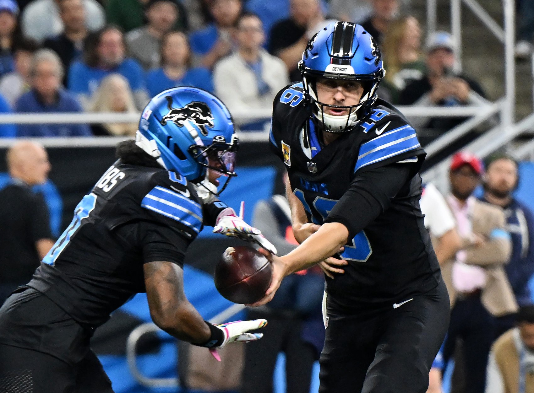 Lions quarterback Jared Goff (16) hands off to Lions running back Jahmyr Gibbs (0) in the first quarter. Detroit Lions take on the Green Bay Packers on Oct. 25, 2026 at Ford Field in Detroit.