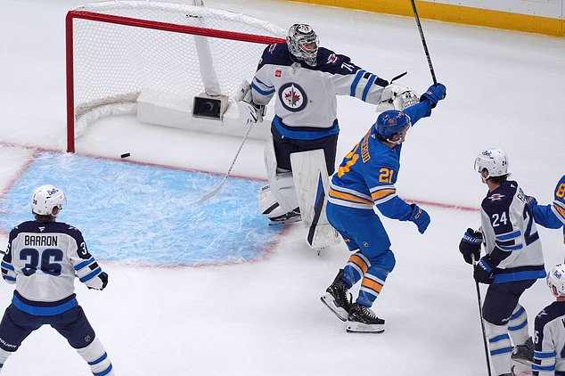 St. Louis Blues' Jimmy Snuggerud (21) celebrates after scoring past Winnipeg Jets goaltender Stuart Skinner (74) during the first period of an NHL hockey game Tuesday, Oct. 20, 2026, in St. Louis. (AP Photo/Jeff Roberson)