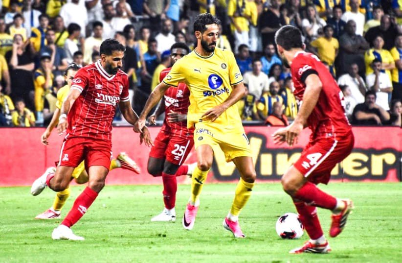 REIGNING CHAMPION Hapoel Beersheba (in red) and Maccabi Tel Aviv (in yellow) battle for possession as the two Israeli giants prepare for another season of Premier League competition, which begins this weekend.