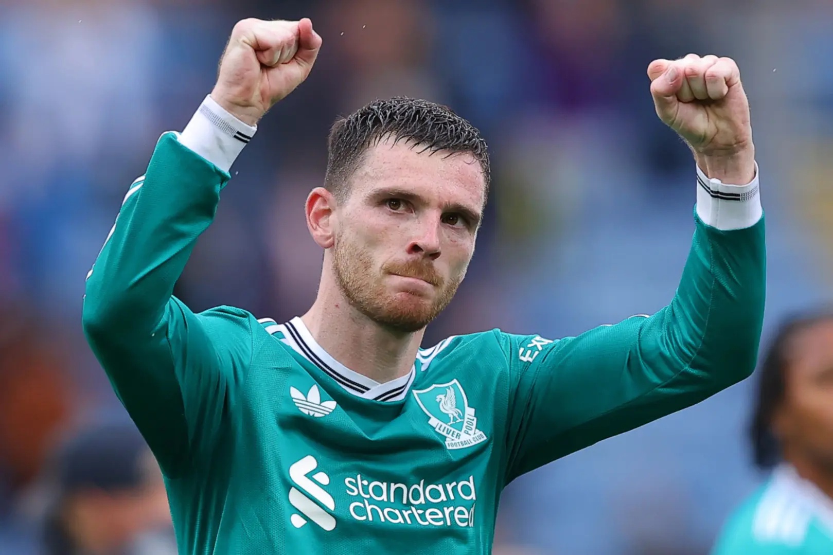 Andy Robertson with his arms raised aloft.