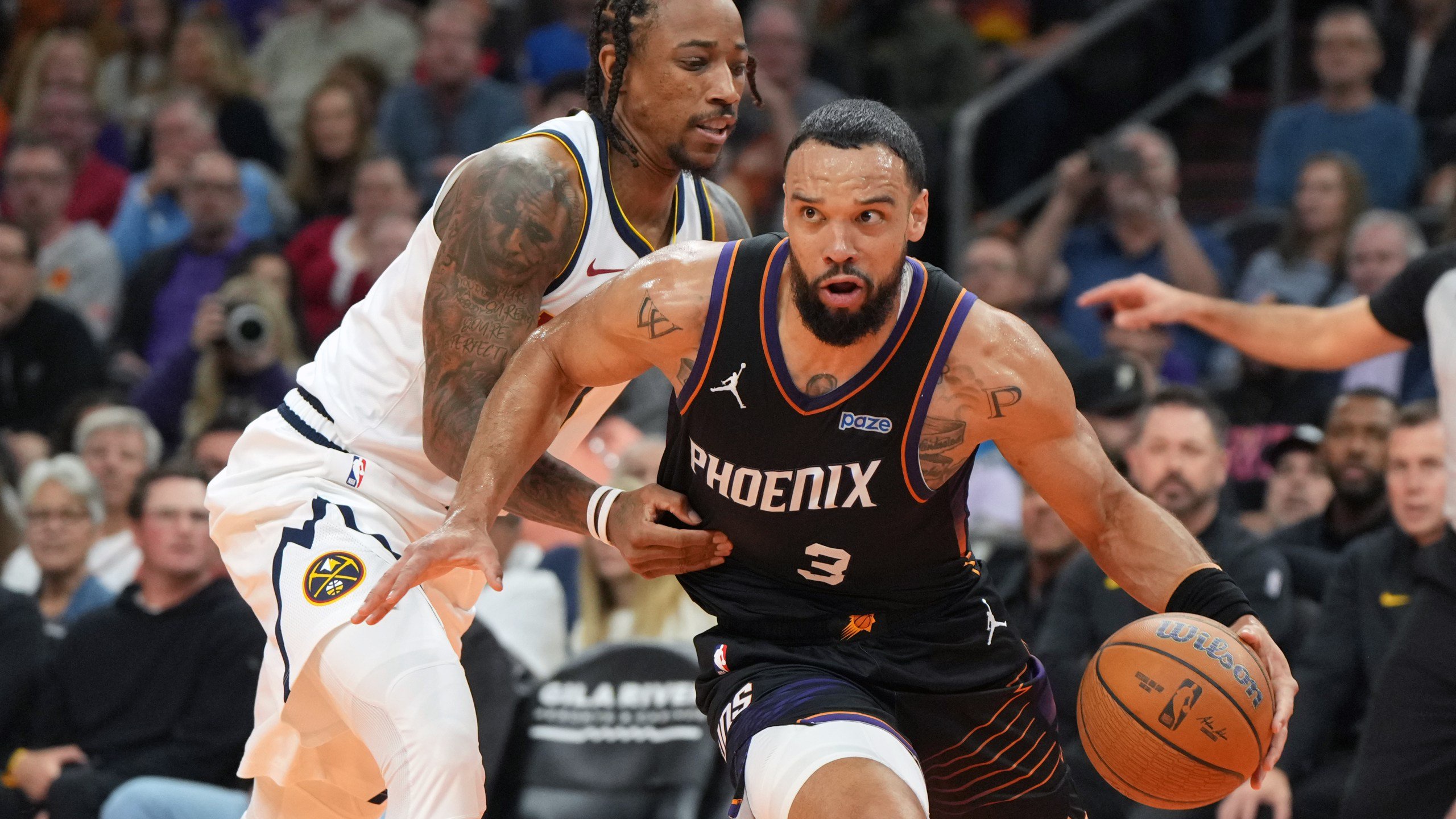 Phoenix Suns forward Dillon Brooks (3) drives around Denver Nuggets guard DeMar DeRozan, left, during the first half of an NBA Cup basketball game, Friday, Oct 30, 2026, in Phoenix. (AP Photo/Rick Scuteri)