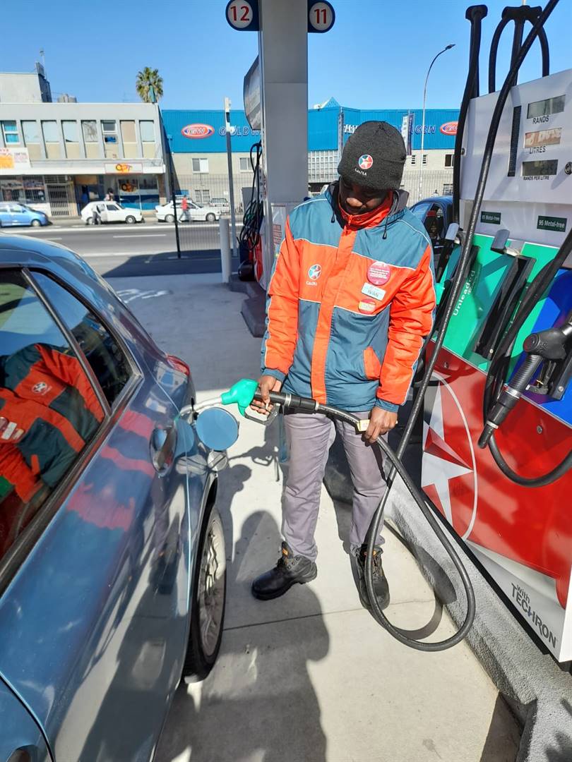 Ivan Xabanisa fills up a car as motorists top up their tanks before another hike hits. Photo by Misheck Makora