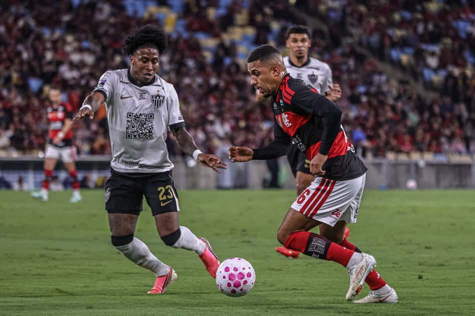 Preciado e Lino disputam bola no Flamengo x Atlético, diante de torcida.