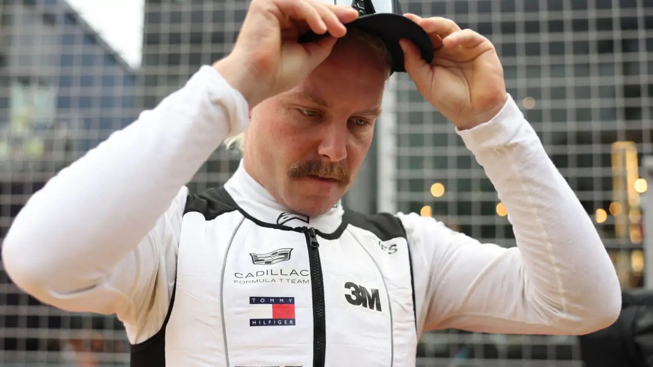 Valtteri Bottas putting on his cap while standing on the grid