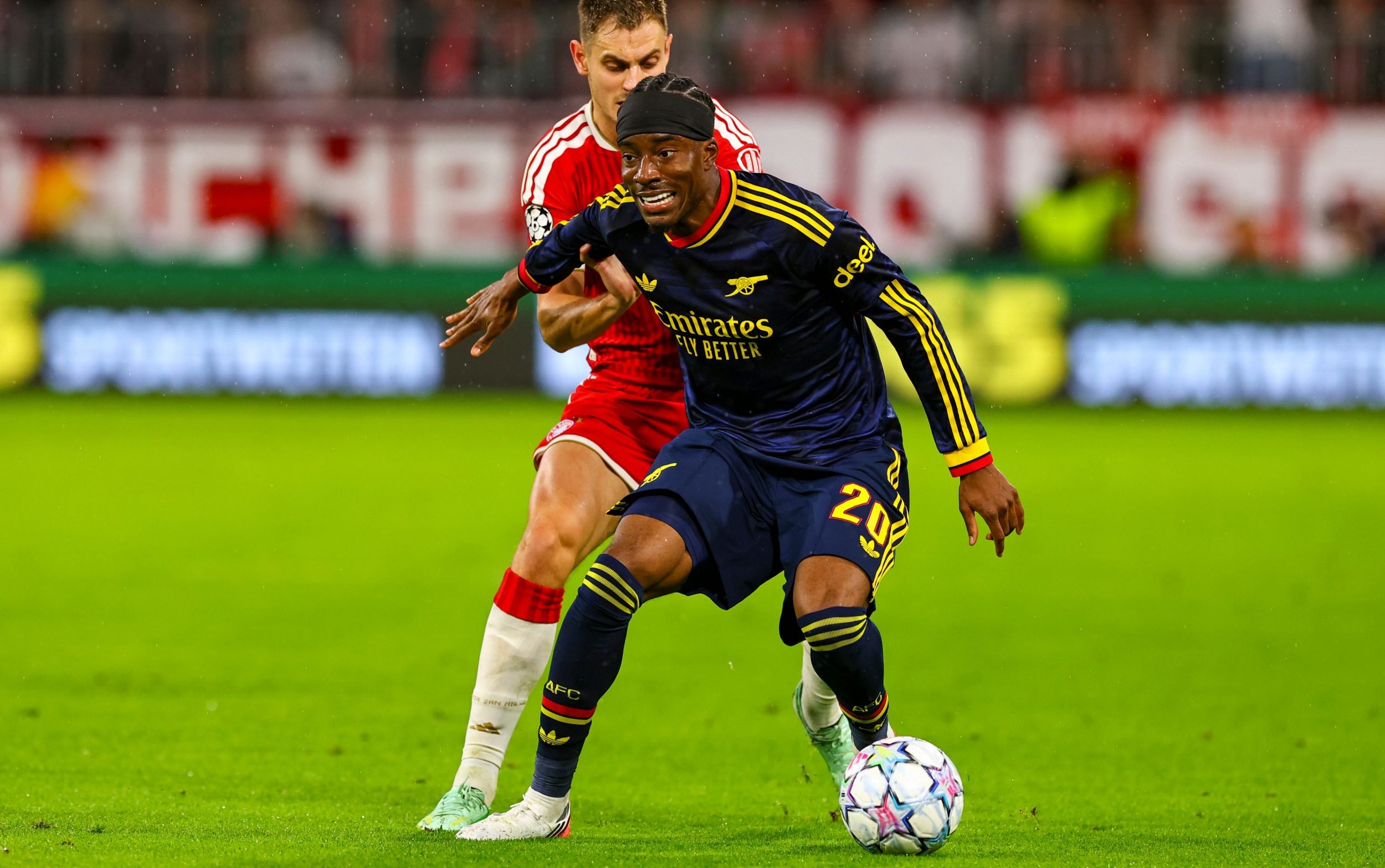 Noni Madueke holds off Bayern Munich's  Josip Stanisic