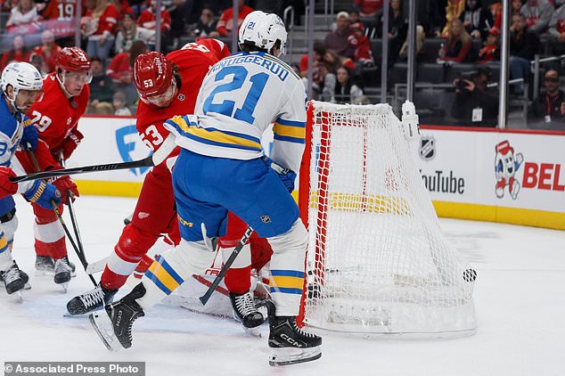 St. Louis Blues right wing Jimmy Snuggerud (21) scores past Detroit Red Wings defenseman Moritz Seider (53) and goaltender John Gibson during the second period of an NHL hockey game Saturday, Oct. 31, 2026, in Detroit. (AP Photo/Duane Burleson)