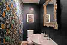 The bathroom in the house with dark walls and a colourful wallpaper accent wall