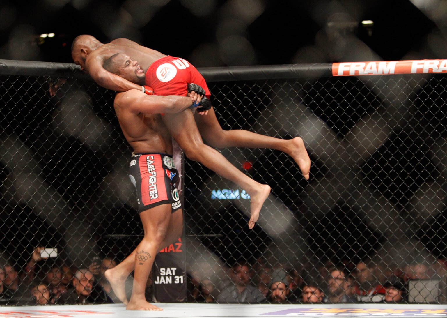 Jon Jones is lifted up by Daniel Cormier during their fight at UFC 182