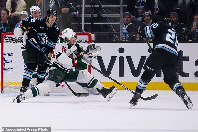 Minnesota Wild center Tyler Pitlick (19) slides to block the shot of Utah Mammoth defenseman Andrew Peeke (20) during the third period of an NHL hockey game Tuesday, Oct. 27, 2026, in Salt Lake City. (AP Photo/Tyler Tate)