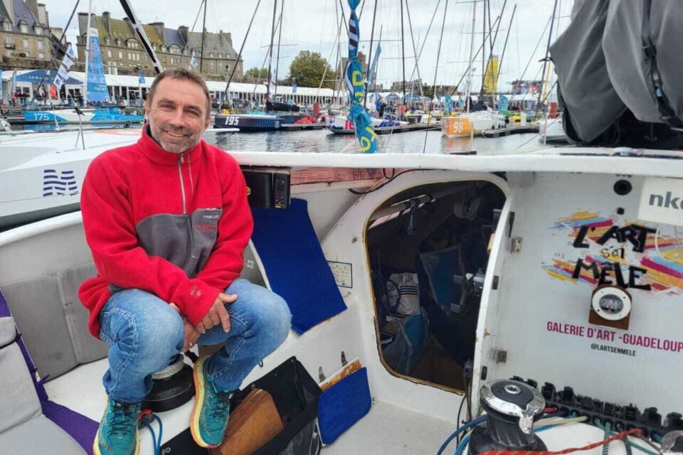 Yanick Rebuffat assis à l'arrière de son Class40 nommé Mussolo 40, affiche un large sourire avant sa première Route du Rhum.