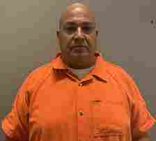 Former Uvalde school police chief Pedro 'Pete' Arredondo pictured in an orange jumpsuit after being indicted over their botched response to a school massacre on May 24, 2022