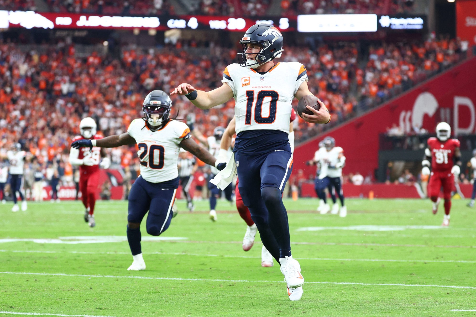 Denver Broncos quarterback Bo Nix runs to score a touchdown against the Arizona Cardinals during the first half at State Farm Stadium.