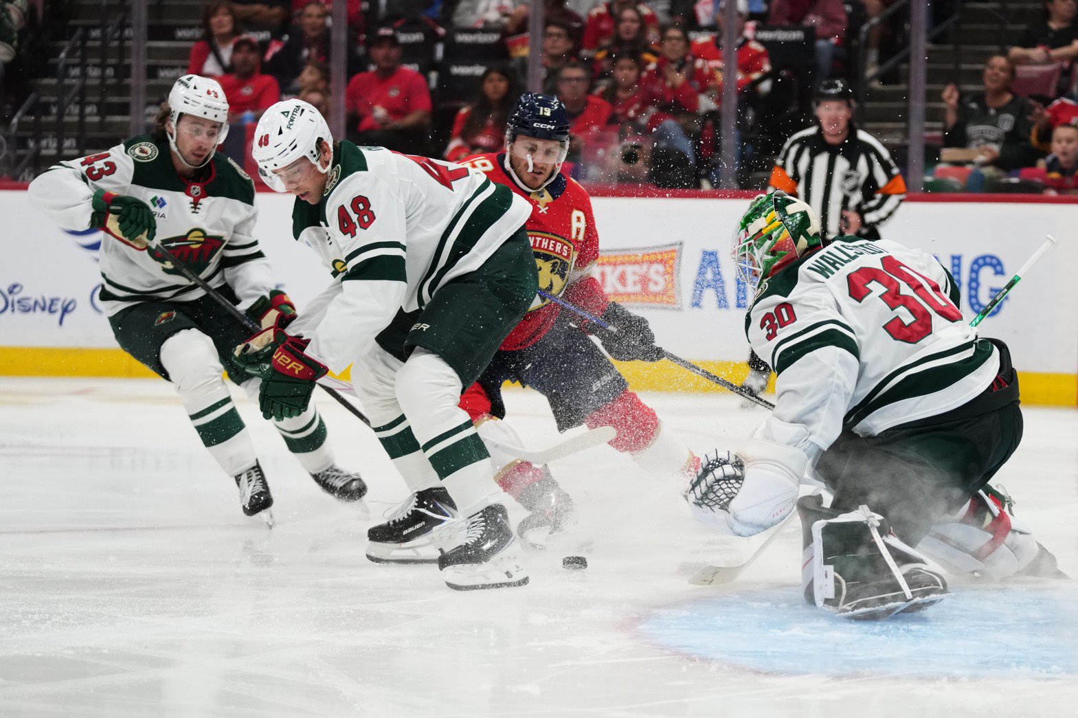 Wild goaltender Jesper Wallstedt and defenseman Daemon Hunt defend the goal against Florida