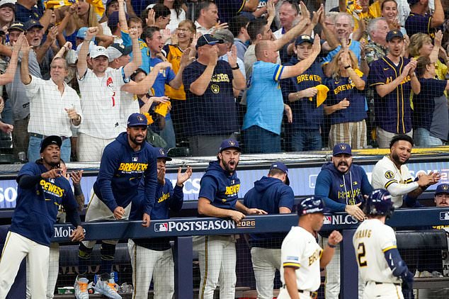 Milwaukee Brewers players and fans cheer during the eighth inning of Game 2 of baseball's National League Championship Series between the Milwaukee Brewers and the Los Angeles Dodgers, Monday, Oct. 12, 2026, in Milwaukee. (AP Photo/Kayla Wolf)