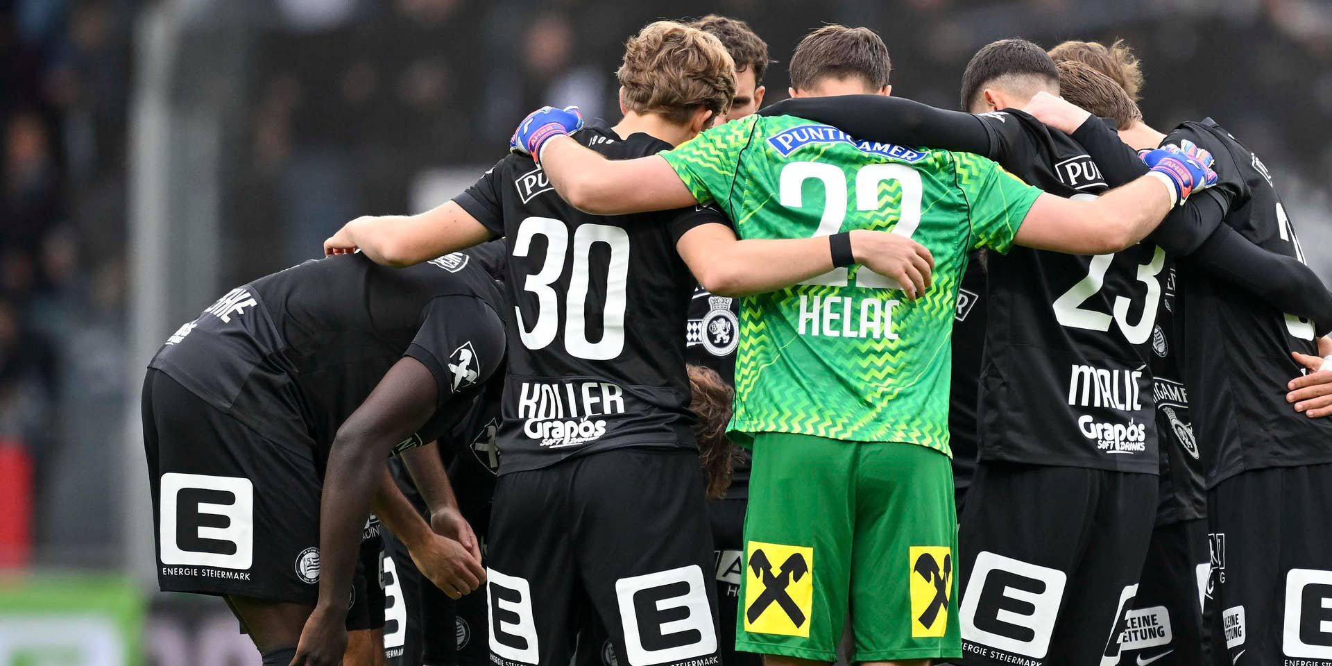 Fußballspieler von Sturm Graz stehen im Kreis und umarmen sich vor dem Spiel.