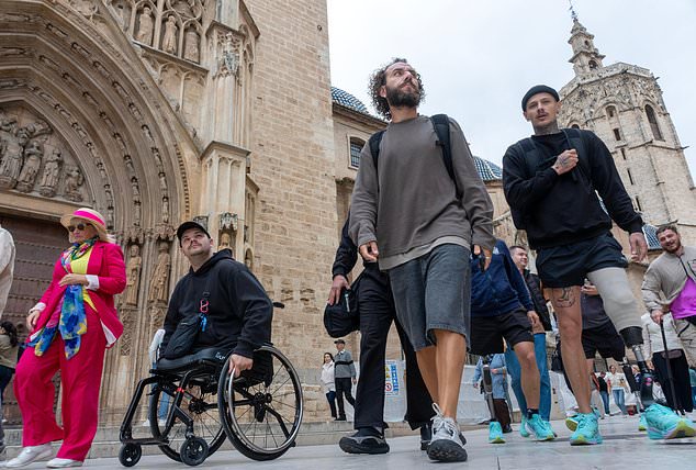 From left, Ukrainian veterans Dmytro Bykhovchenko, Oleh Tserkovnyy and Oleksii Doroshenko walk through Valencia, Spain, Sunday, Oct. 18, 2026. (AP Photo/Alberto Sáiz)