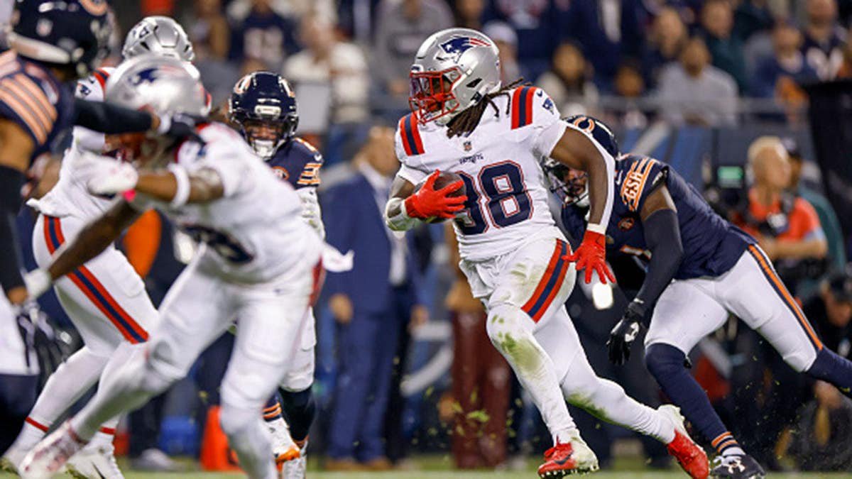 Rhamondre Stevenson runs with the ball during an NFL game at Soldier Field.