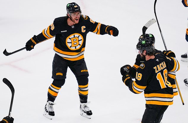 Boston Bruins' David Pastrnak, left, celebrates after a goal by Elias Lindholm off Nashville Predators goalie Justus Annunen during the first period of an NHL hockey game, Thursday, Oct. 22, 2026, in Boston. (AP Photo/Charles Krupa)