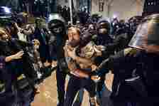 Police officers detain a protestor as other gather outside the parliament building in Tbilisi, Georgia, on Tuesday, April 16, 2024, to protest against "the Russian law" similar to a law that Russia uses to stigmatize independent news media and organizations seen as being at odds with the Kremlin. (AP Photo/Zurab Tsertsvadze)