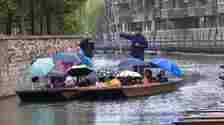 Tourists under blankets and umbrellas as they go for a punt on the River Cam on Tuesday
