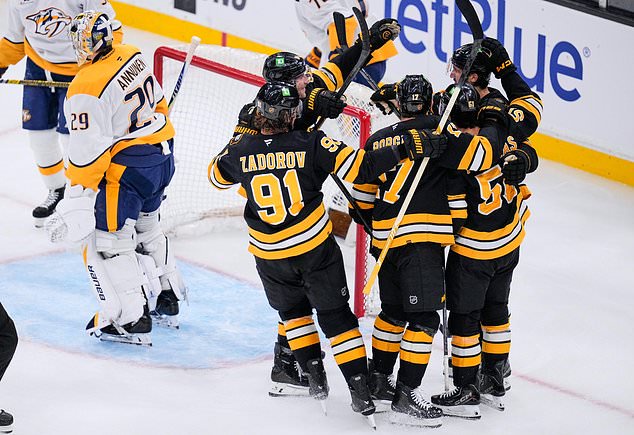 Boston Bruins, right, celebrate after a goal by Mark Kastelic, as Nashville Predators' Justus Annunen, left, skates away during the third period of an NHL hockey game, Thursday, Oct. 22, 2026, in Boston. (AP Photo/Charles Krupa)