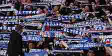 Rangers supporters hold their scarves aloft.