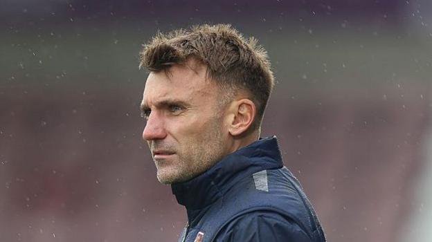Northampton Town boss Chris Hogg looking on with the rain surrounding him