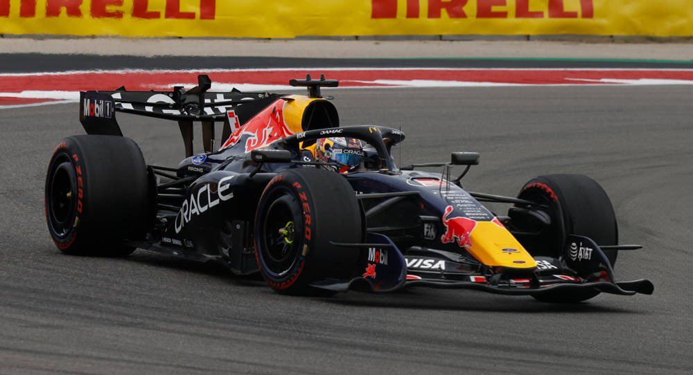 Red Bull Racing F1 car in navy and yellow with Oracle and Visa livery, Ford-backed, on track at a Pirelli-lined circuit