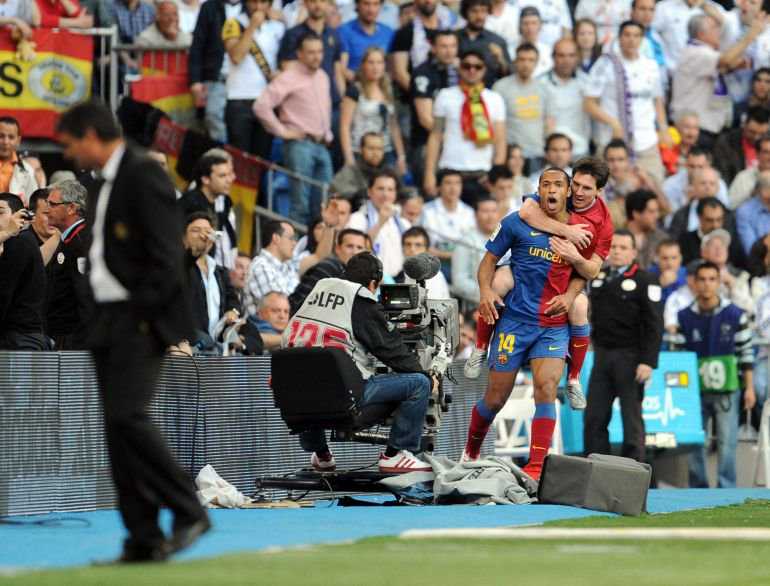Barcelona's French Thierry Henry (C) celebrates with teammate Argentinian Lionel Messi after scoring the first goal against Real Madrid during a Spanish league football match at Santiago Bernabeu stadium in Madrid on May 2, 2009. AFP PHOTO/JAVIER SORIANO. (Photo by JAVIER SORIANO / AFP)