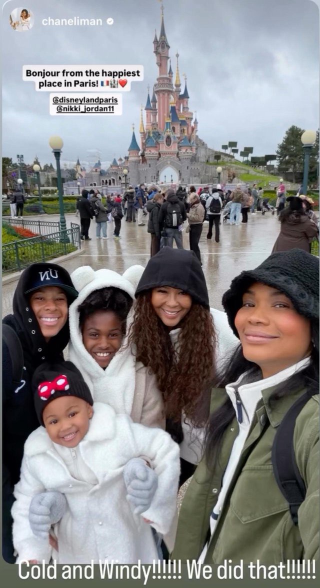 Nikki Jordan and Chanel Iman posing for a selfie in front of the castle at Disneyland Paris with three children.
