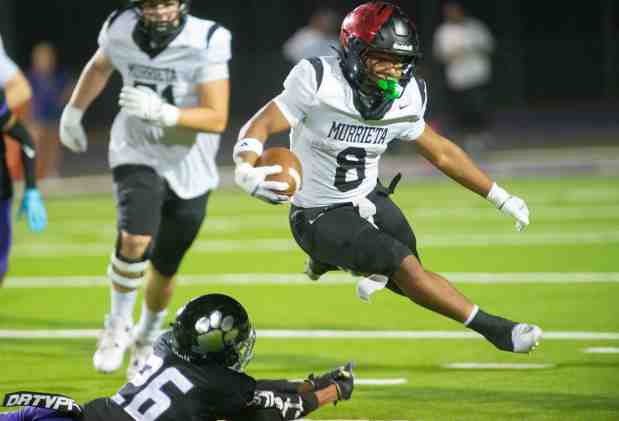 Murrieta Valley running back Tahj Stephens, (#8), jumps and avoids the tackle from Rancho Cucamonga's Kingston Penn, (#26), in a non-league football game at Rancho Cucamonga High in Rancho Cucamonga, August 20, 2026. The Cougar defeated the Nighthawks 28-14, in the season opener. (Photo by John Valenzuela/Contributing Photographer)