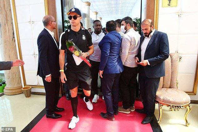 Sporting sunglasses and clasping some roses, Ronaldo makes his arrival at Tehran Airport