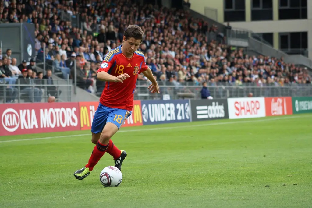 Ander Herrera in a red Spain U-21 kit controlling a football on the pitch.