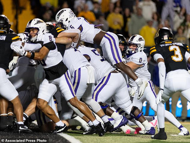 James Madison running back George Pettaway (6) leaps over the line to score a touchdown during the first half of an NCAA college football game against Appalachian State in Boone, N.C., Thursday, Oct. 22, 2026. (Daniel Lin/Daily News-Record Via AP)