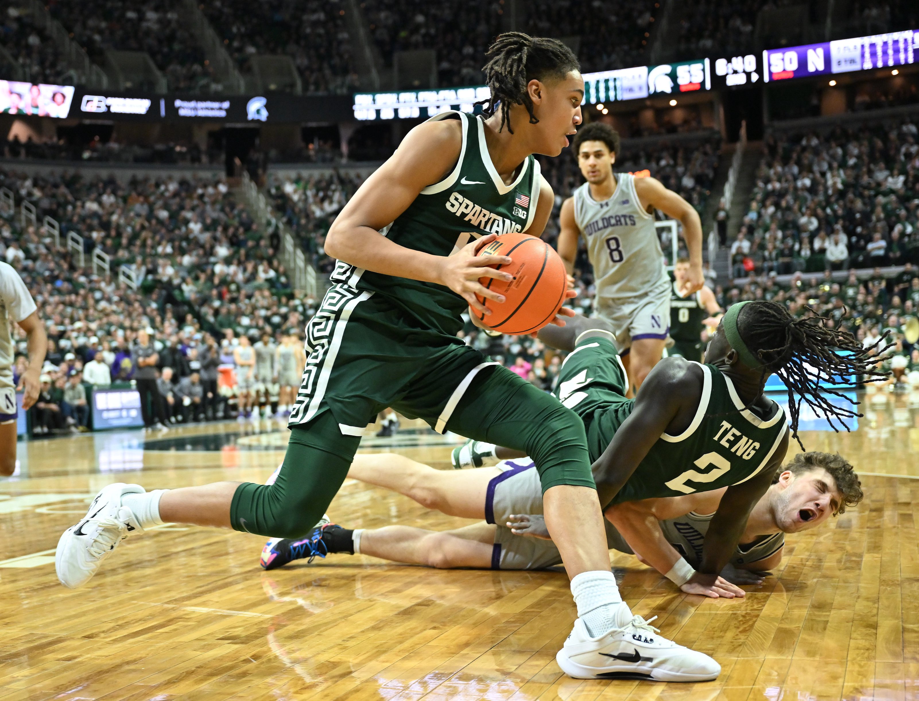 Michigan State University’s Jordan Scott dribbles around teammate Kur Teng and Northwestern’sNick Martinelli who crashed into one another in the second half at the Breslin Center in East Lansing, Michigan on January 8, 2026.