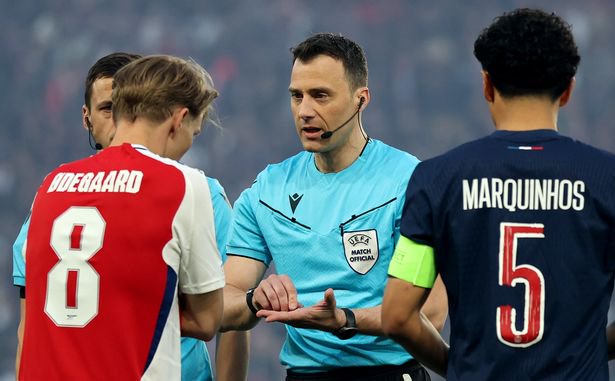 Referee Felix Zwayer is seen with Martin Odegaard of Arsenal and Marquinhos of Paris Saint-Germain during the coin toss for the UEFA Champions League 2024/25 Semi Final Second Leg match between Paris Saint-Germain and Arsenal FC at Parc des Princes on May 07, 2025 in Paris, France