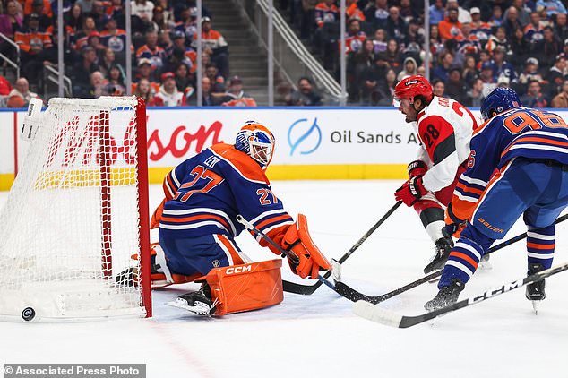 Edmonton Oilers goaltender Devon Levi (27) defends the net against Carolina Hurricanes' William Carrier (28) during the first period of an NHL hockey game in Edmonton, Alberta, Thursday, Oct. 22, 2026. (Codie McLachlan/The Canadian Press via AP)