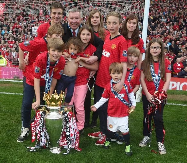 Manager Sir Alex Ferguson of Manchester United squad celebrates with his grandchildren after the Barclays Premier League match between Manchester United and Swansea at Old Trafford on May 12, 2013 in Manchester, England