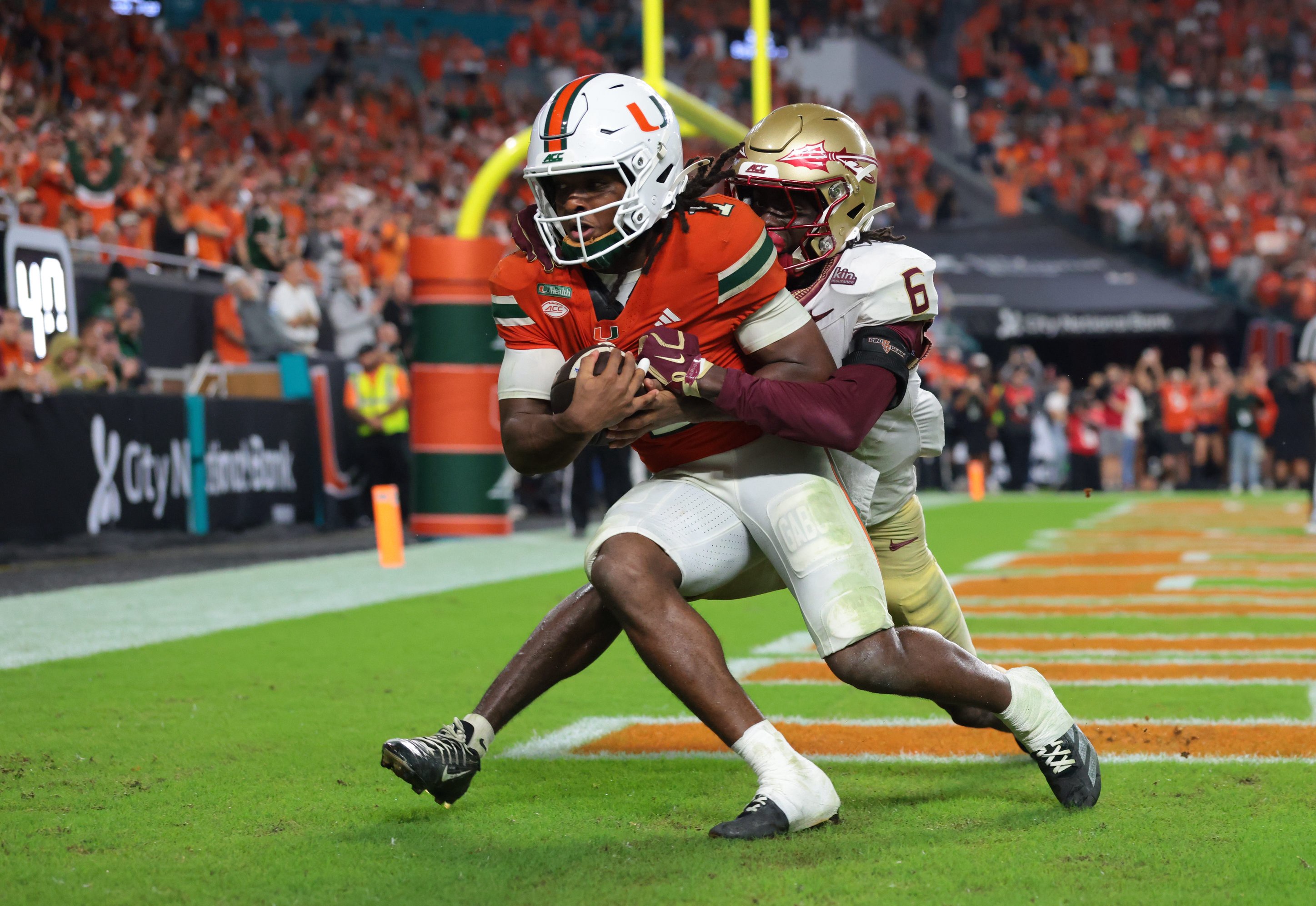 Oct 17, 2026; Miami Gardens, Florida, USA;  Miami Hurricanes wide receiver Malachi Toney (1) catches a touchdown against Florida State Seminoles defensive back Ja'Bril Rawls (6) during overtime at Hard Rock Stadium.  Mandatory Credit: Sam Navarro-Imagn Images