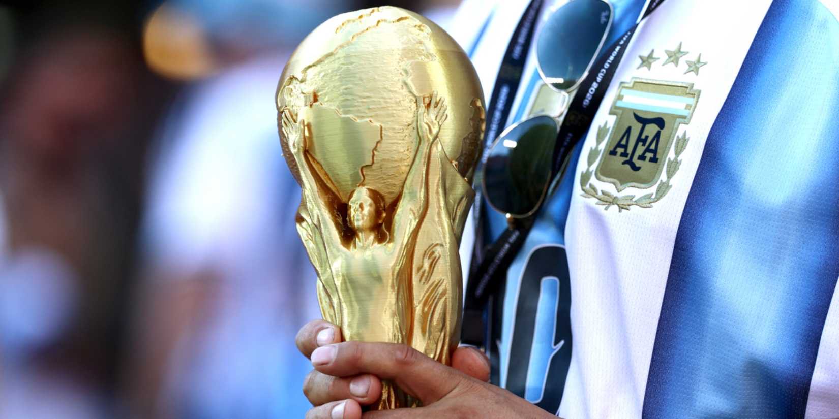 Argentina fan holds replica World Cup trophy inside the stadium before the match