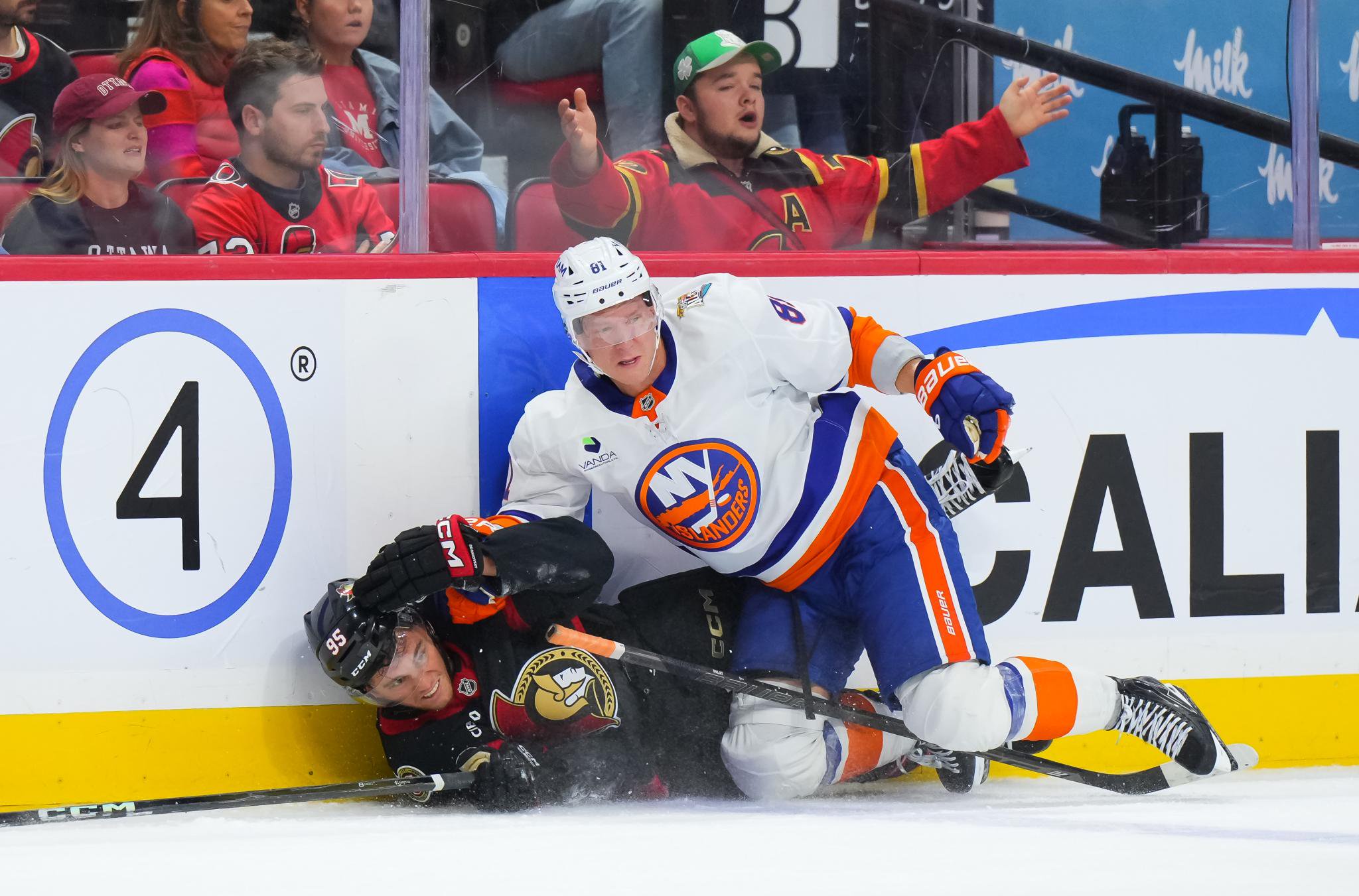 Andre Burakovsky of the Ottawa Senators falls to the ice as he battles for position against Ondrej Palat of the New York Islanders.