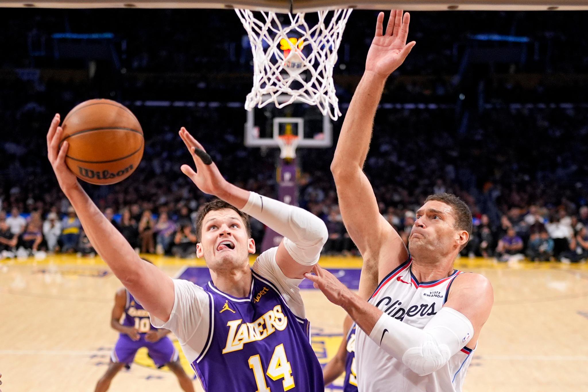 Los Angeles Lakers center Walker Kessler shoots as LA Clippers center Brook Lopez defends during an NBA game.