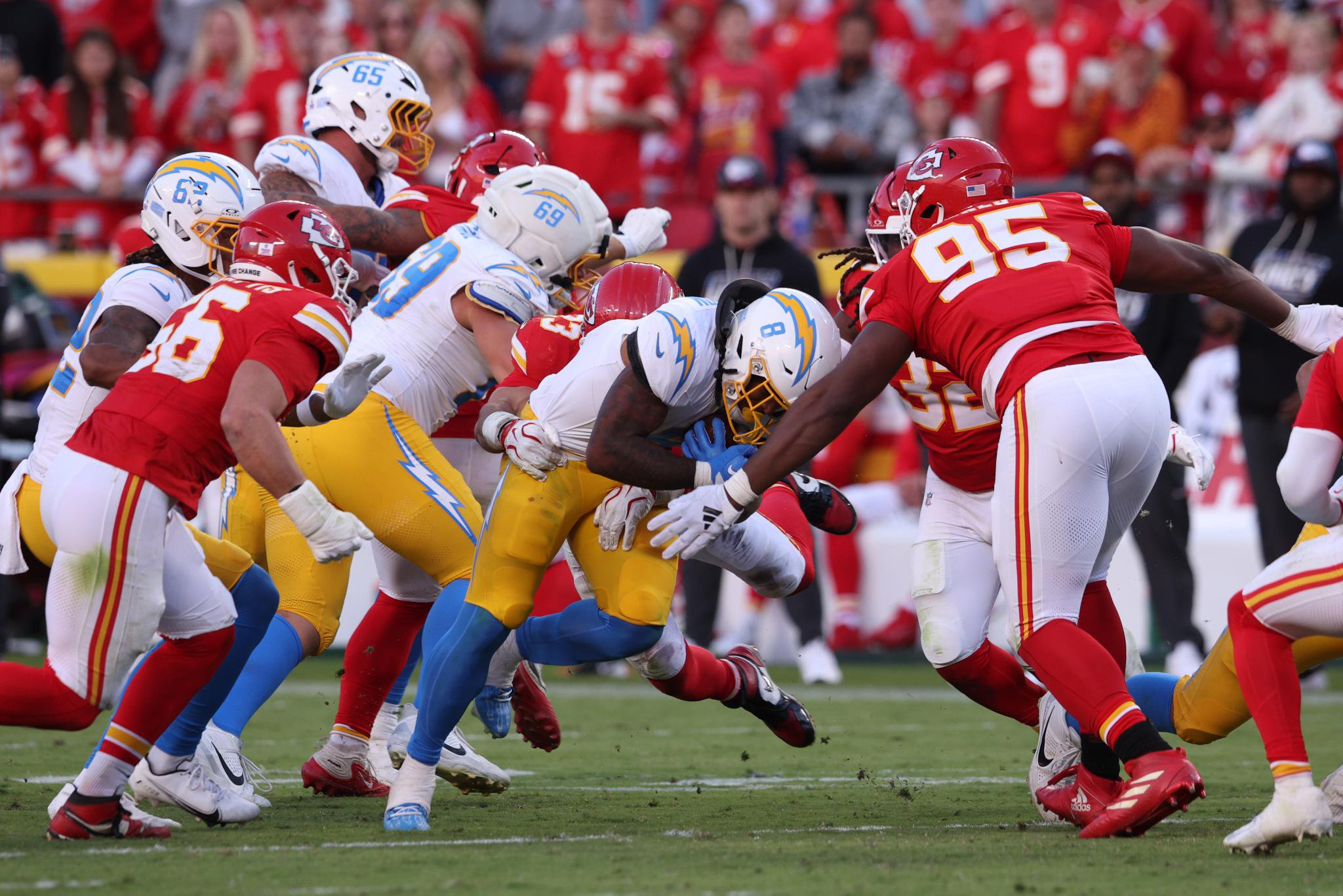 Los Angeles Chargers running back carries the ball against the Kansas City Chiefs defense during an NFL game.
