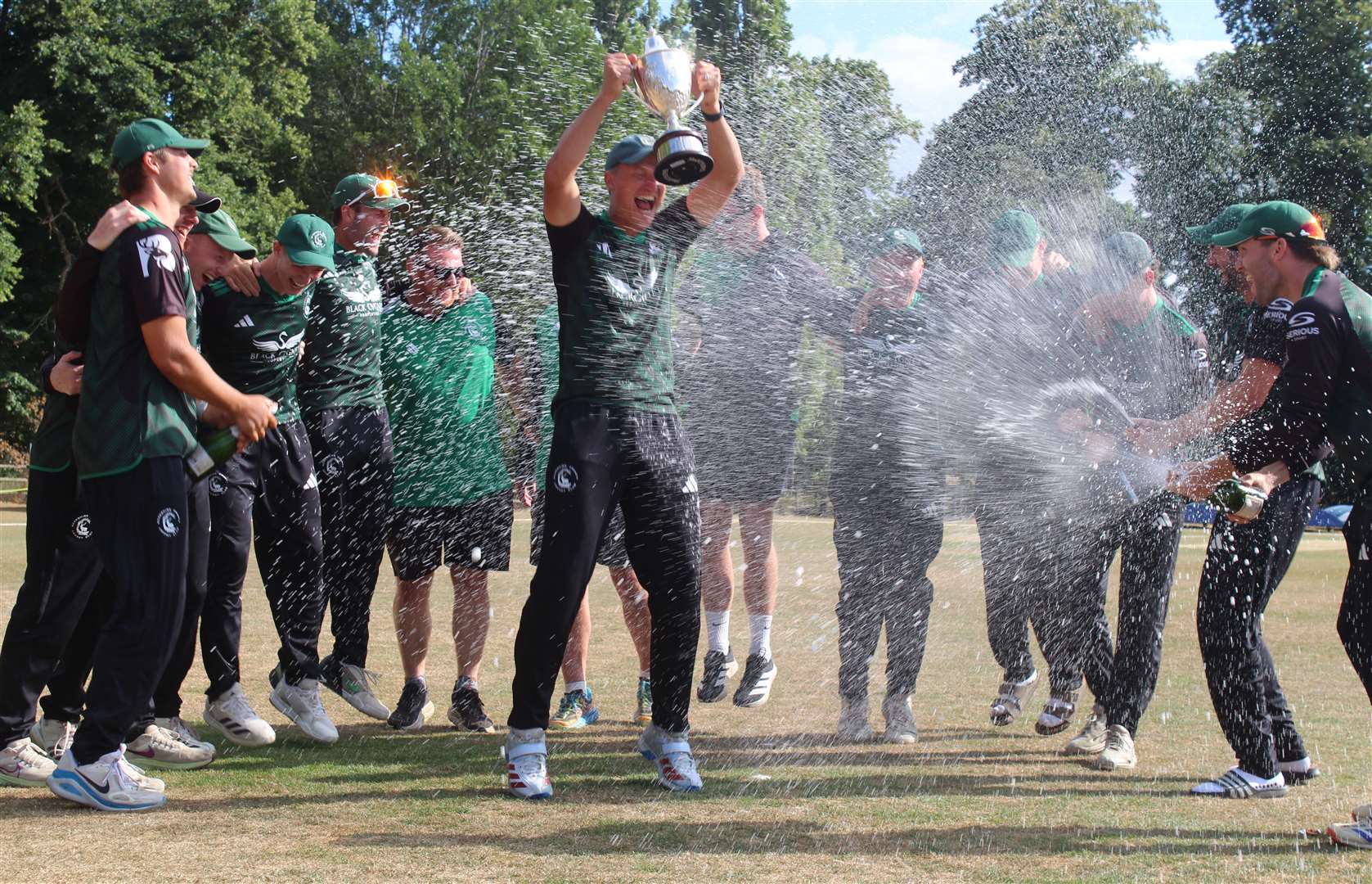 Berkshire skipper Andy Rishton holds the trophy aloft as he celebrates with his team-mates after winning the NV Play NCCA One Day Trophy Final at Copdock & Old Ipswichian CC. Picture: Nick Garnham