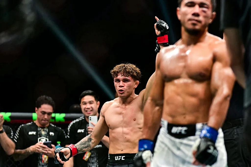 Britain's Lone'er Kavanagh raises his hand in victory after his flyweight fight against Uzbekistan's Ramazonbek Temirov.