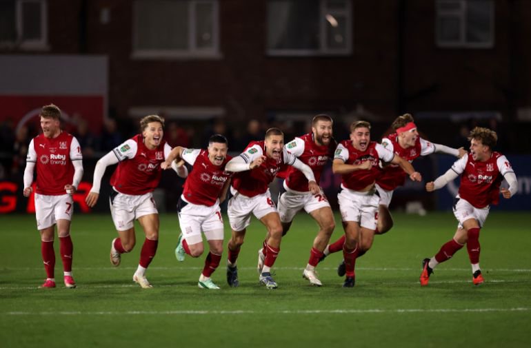 FLEETWOOD, ENGLAND - OCTOBER 27: Fleetwood Town players celebrate after Jay Lynch of Fleetwood Town saves a penalty from Bruno Guimaraes of Arsenal to win the match during the Carabao Cup Fourth Round match between Fleetwood Town and Arsenal at Highbury Stadium on October 27, 2026 in Fleetwood, England. (Photo by Carl Recine/Getty Images)